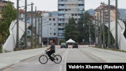 Një person duke kaluar me biçikletë në urën mbi lumin Ibër në Mitrovicë. Fotografi ilustruese nga arkivi. 