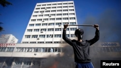 A protester stands near a fire set in front of a government building in Tuzla, Bosnia-Herzegovina, earlier this year. The Freedom House report describes the Balkan country as the "poster child" of dysfunctional government.