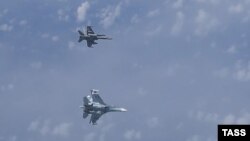 Rusiya Müdafiə Nazirliyinin yaydığı videodan: F-18 (yuxarıda) və Su-27 qırıcıları 