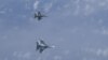 Rusiya Müdafiə Nazirliyinin yaydığı videodan: F-18 (yuxarıda) və Su-27 qırıcıları 