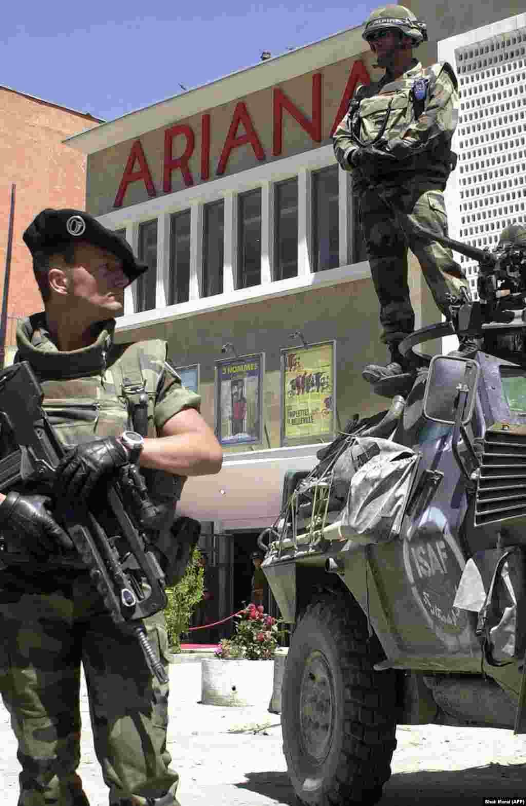 French soldiers from the International Security Assistance Force (ISAF) stand guard outside Kabul’s Ariana Cinema on May 23, 2004, during an earlier reopening ceremony. The landmark theater, destroyed during Afghanistan’s 1992-1996 civil war, was restored through a French-led reconstruction effort