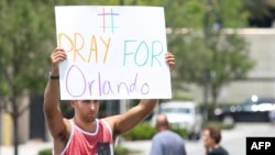 A lone man holds a vigil outside the Orlando Regional Medical Center in the aftermath of the worst mass shooting in U.S. history.