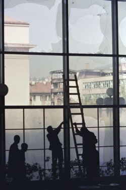 Работници поставят пластмасови плоскости, за да покрият счупените прозорци на хотела през септември 1992 г.