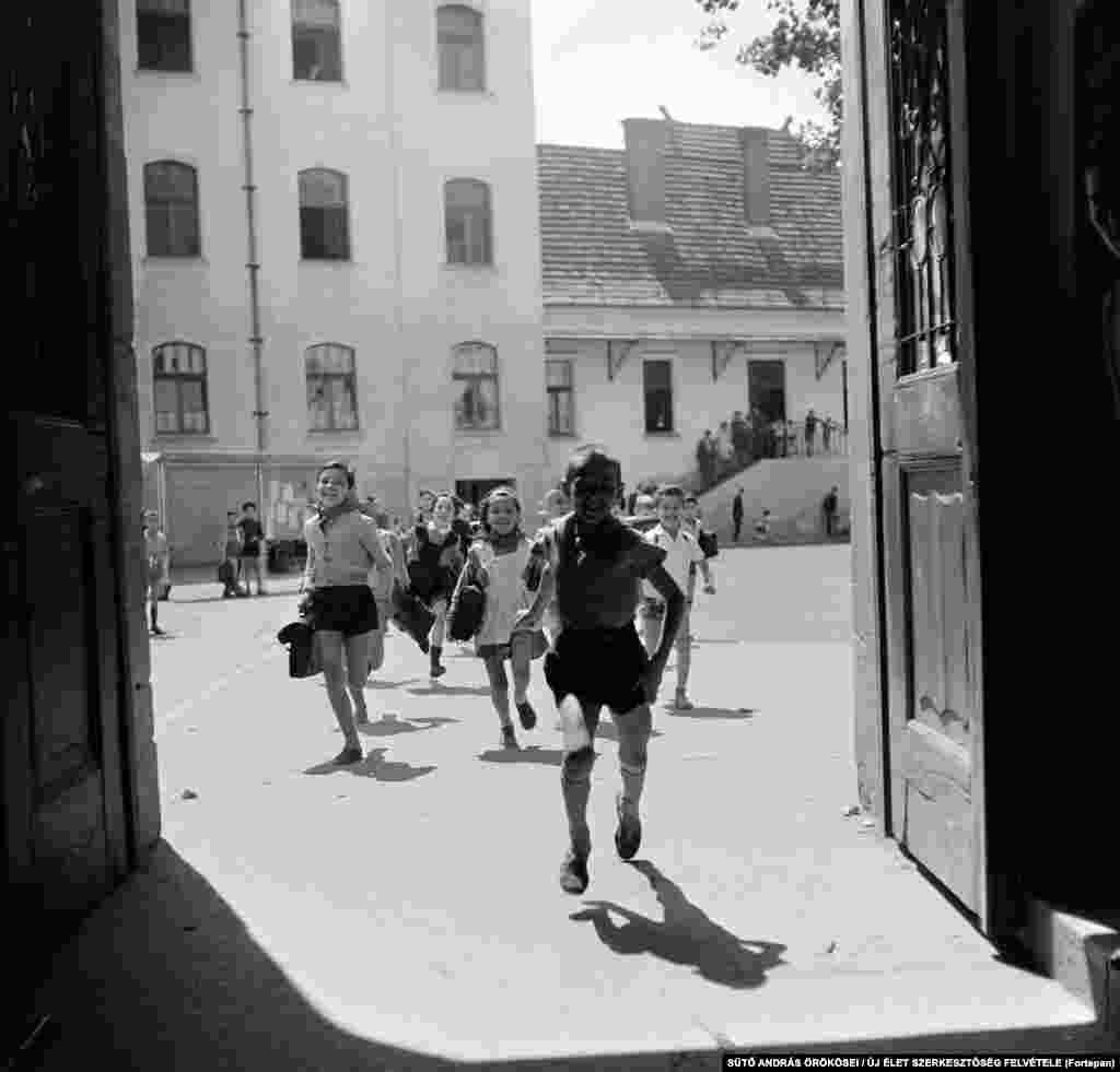 Schoolchildren wearing the red scarves of the communist Pioneer youth group run into a building in Targu Mures in 1964.