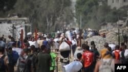 عکس خبرگزاری فرانسه از آوارگان فلسطینی در اردوگاه نصیرات که روز شنبه موفق به دریافت بستههای غذایی از یک مرکز توزیع شدند