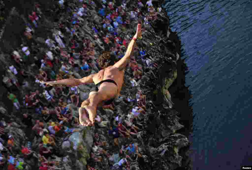 A man jumps off a bridge into the Soca River during a traditional diving competition in Slovenia. (Reuters/Srdjan Zivulovic)