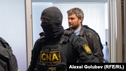 Valeriu Ceban (dreapta), ofițer INI, adus de CNA la Judecătoria Ciocana