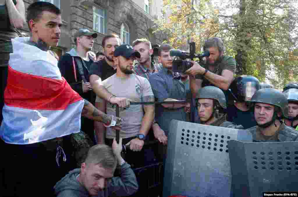 Foreign volunteers chain themselves to a fence during a protest of Ukrainian activists in front of the presidential office in Kyiv on September 20. (EPA-EFE/Stepan Franko)