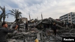Palestinienii caută victime la locul unei lovituri israeliene asupra unei case în Rafah, în sudul Fâșiei Gaza. 20 decembrie 2023