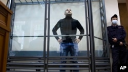Andrei Pivovarov stands behind the glass during a court session in Krasnodar on June 2.