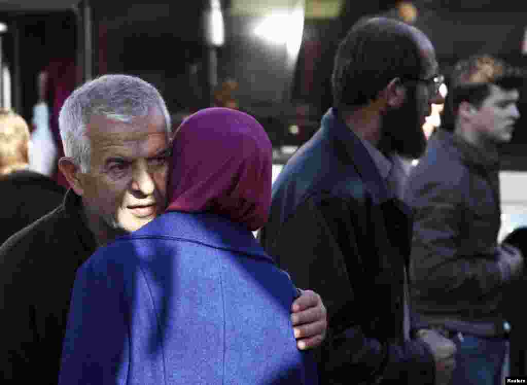 Albanians say goodbye to each other as they wait for a bus to go to EU.