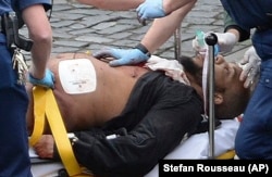 The suspected attacker, Khalid Masood, is treated by emergency services after being shot by police outside the British Parliament in London. He later died of his wounds.