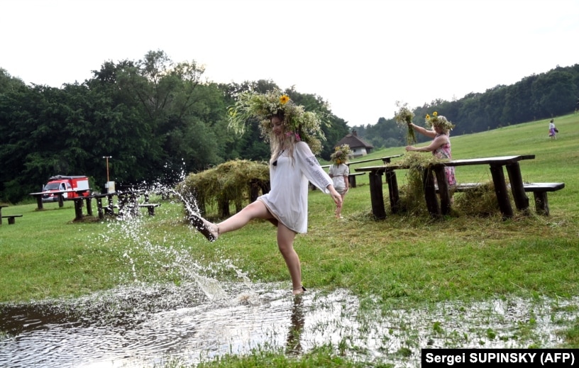 A girl wearing traditional Ukrainian clothes dances in a puddle after heavy rain during celebrations of the Kupala night in Pyrohiv, near Kyiv, on July 6. During the celebration, an ancient Slavic ritual related to the summer solstice, people wear wreaths, jump over fires, and bathe naked in rivers and lakes.