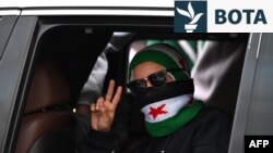 Një grua ngre dy gishta teksa sirianët festojnë njëvjetorin e rrëzimit të sundimtarit të kamotshëm Bashar al-Assad në Damask, më 8 dhjetor.