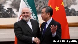 محمدجواد ظریف (چپ) و وانگ یی، وزیران خارجه ایران و چین. آقای ظریف مامور انجام مذاکرات نهایی با طرف چینی برای امضای توافقنامه است.