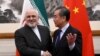 China's Foreign Minister Wang Yi (R) shakes hands with Iran's Foreign Minister Mohammad Javad Zarif during their meeting at the Diaoyutai State Guest House in Beijing on December 31, 2019.