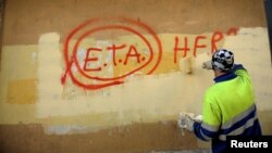 Un lucrător de la primărie dă cu vopsea peste mesajul „ETA, poporul e cu tine”, la Guernica, Spania, după ce ETA a anunțat încetarea definitivă a focului, 21 octombrie 2011.