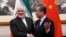 China's Foreign Minister Wang Yi (R) shakes hands with Iran's Foreign Minister Mohammad Javad Zarif during their meeting at the Diaoyutai State Guest House in Beijing on December 31, 2019.