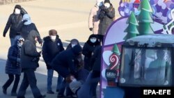 Belarusian policemen detain a protester during an anti-government rally in Minsk on December . 