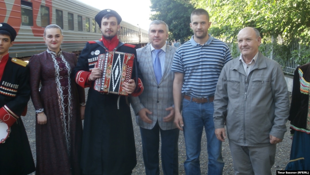 Eugen Martens (second from right) was greeted at the Stavropol railway station by Vladimir Poluboyarenko (right) and his lawyer, Aleksei Abazov, and an amateur musical group that performed a Cossack song and dance.