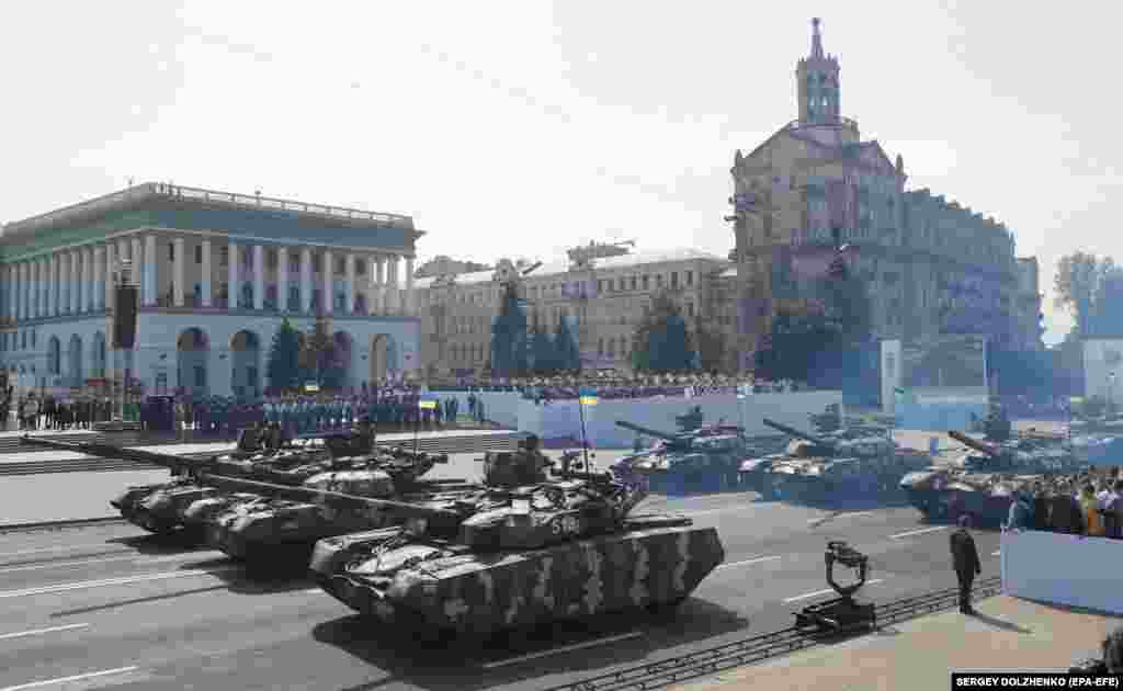 Ukrainian military tanks drive in formation on the streets of Kyiv.