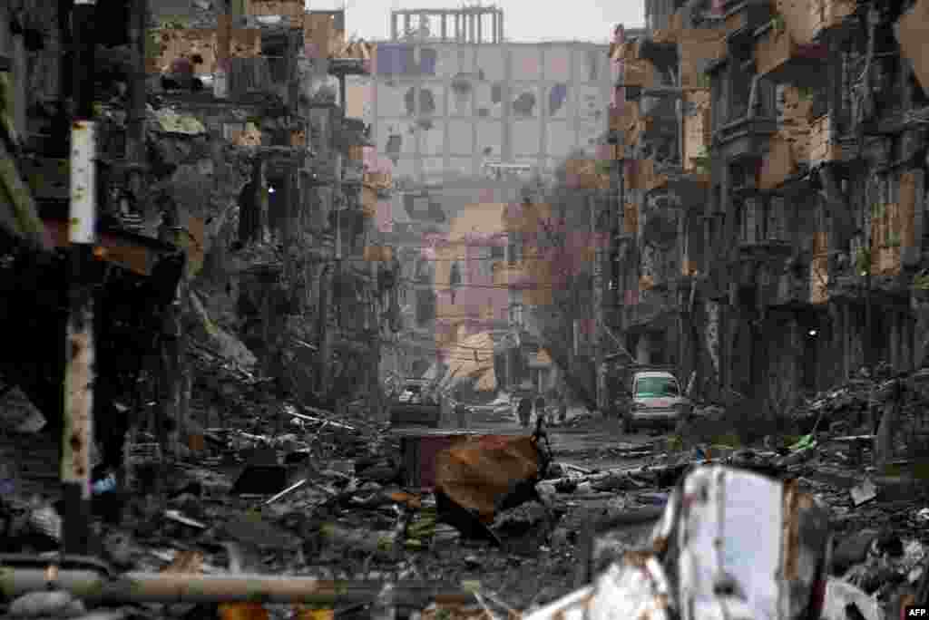People walk amid a devastated section of the northeastern Syrian city of Deir Ezzor, where antigovernment rebels have united against jihadists they accuse of atrocities worse than those perpetrated by the regime of President Bashar al-Assad. (AFP/Ahmad Aboud)