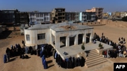 Afghan men and women wait in lines for voter-identification documents outside a registration center in Herat Province last month.