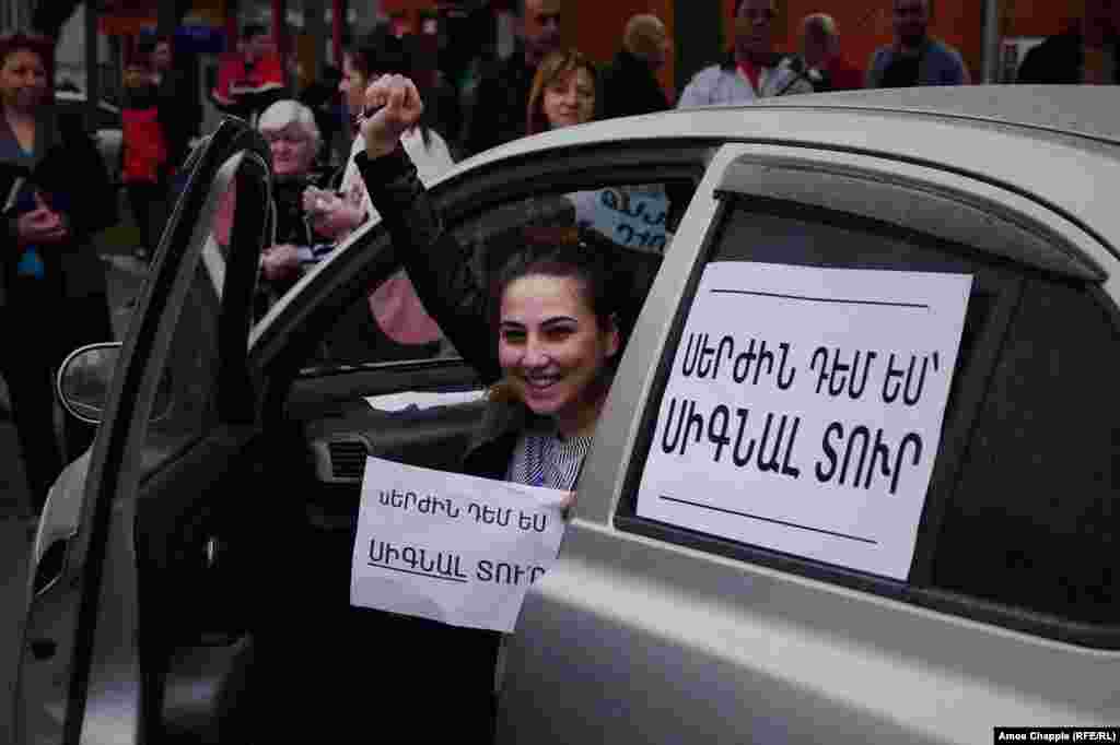 The sign on the car says: "Deny Serzh by honking your horn."