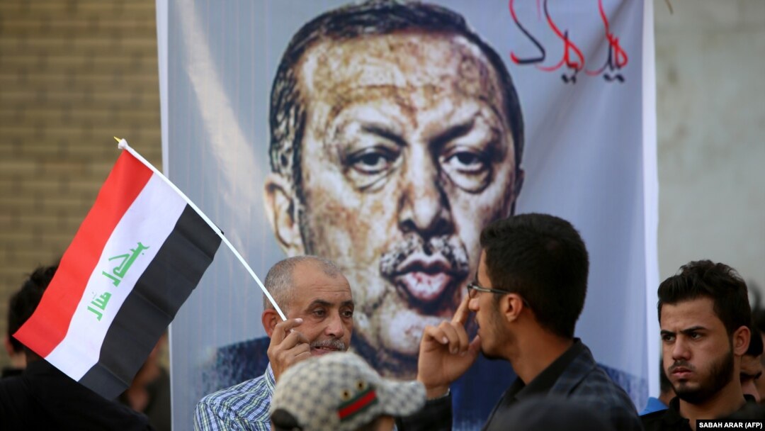 Iraqis stand in front of a banner mocking Turkish President Recep Tayyip Erdogan during a demonstration in Baghdad on October 8 to demand the withdrawal of Turkish troops from the Bashiqa camp in northern Iraq.