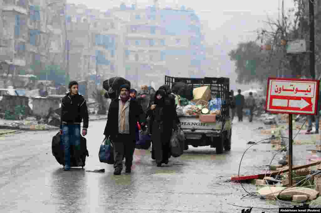 People carry their belongings as they flee deeper into the remaining rebel-held areas of Aleppo, Syria, on December 13. Syrian government forces retook rebel-held territory after a lengthy siege and brutal fighting. (Reuters/Abdalrhman Ismai)