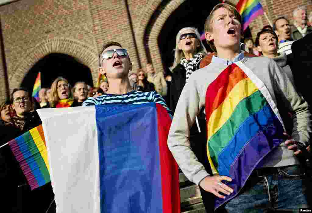 Demonstrators in Sweden sing the Russian national anthem while raising rainbow flags and the Russian flag in solidarity with Russia's lesbian, gay, bisexual, and transgender community as part of a film project called "Live and Let Love," at the Stockholm Olympic Stadium. (Reuters/Erik Martensson)