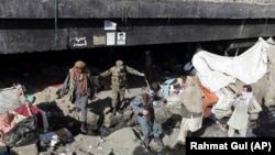 FILE: Afghan health workers and security forces gather suspected drug users during a campaign in October 2017.