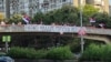 Një grup njerëzish u mblodhën në një urë mbi një autostradë ku vendosën një baner me mbishkrimin "Ratko Mlladiq, hero serb" në Beograd më 3 shtator. 