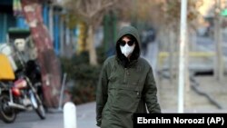 An Iranian woman wears a mask to help guard against dangerous levels of air pollution in Tehran, Iran, Monday, Dec. 23, 2019. 