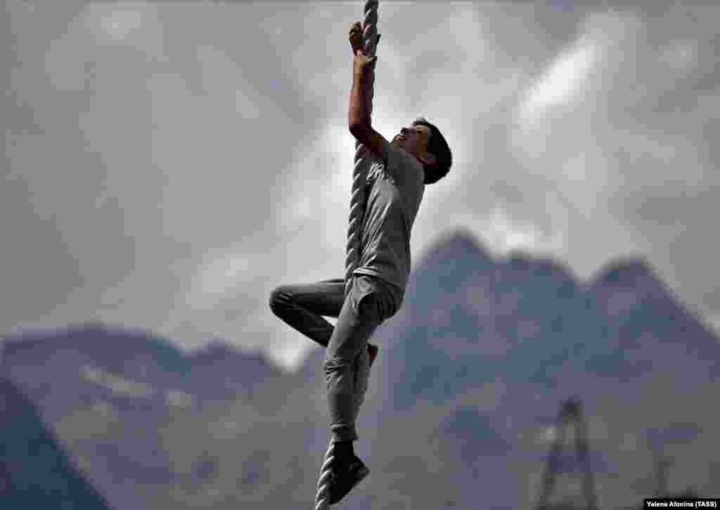 A local boy climbs a rope near Mount Elbrus at a height of 2,000 meters above sea level as part of festivities on August 23 to mark the upcoming Statehood Day of Russia&#39;s Republic of Kabardino-Balkaria.&nbsp;