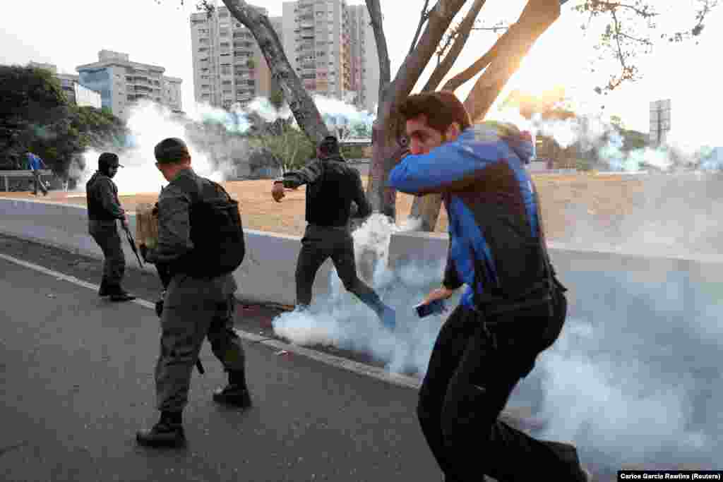 Tear gas landing near a group of armed men near the air base