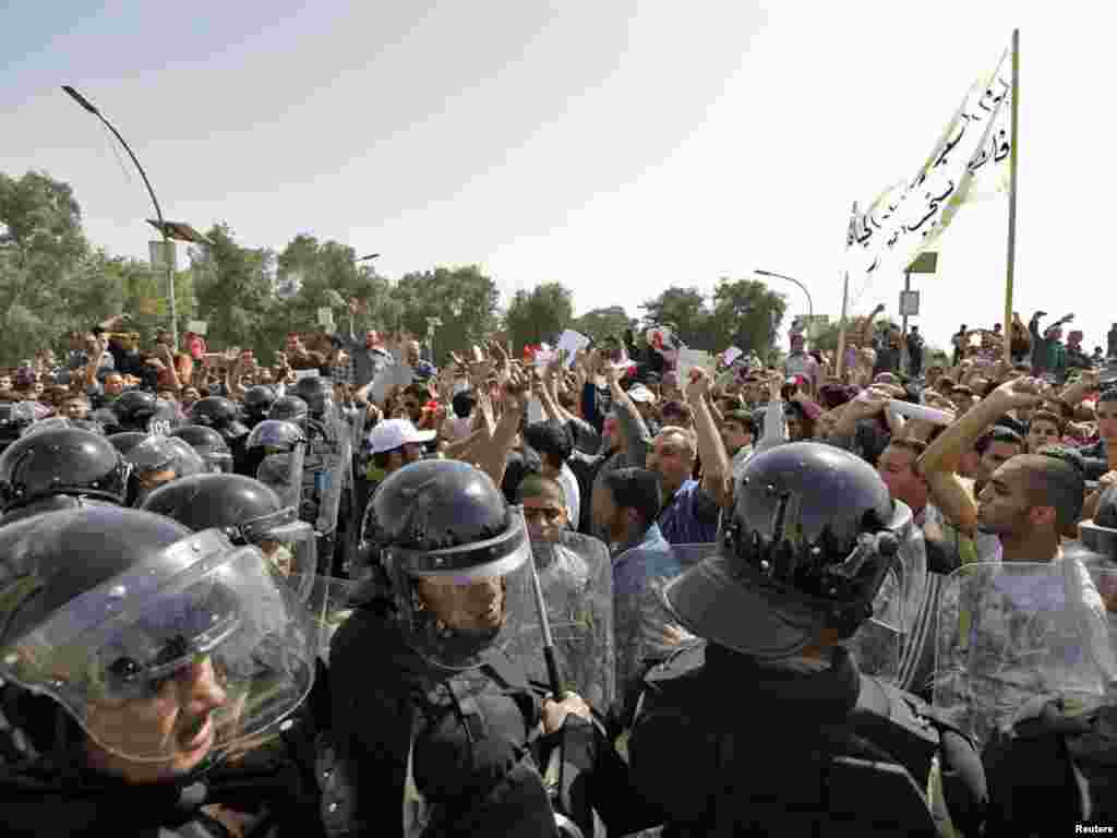 Police dressed in riot gear block protesters in central Baghdad.
