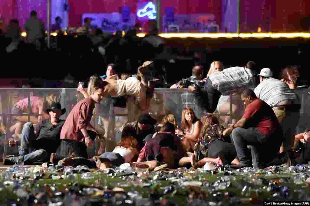 People scramble for shelter at a country music festival after a gunman fired indiscriminately into the crowd from a nearby hotel on October 1 in Las Vegas, Nevada. At least 59 people were killed and more than 500 injured in the largest mass shooting in modern U.S. history. (Getty Images/David Becker)