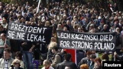 Mourners await the start of the commemoration service in the Polish capital for Lech Kaczynski, his wife, and other victims of the Smolensk crash.