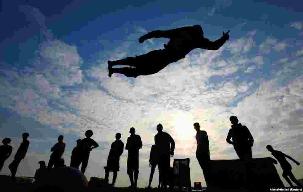 An Iraqi demonstrator performs a somersault as he practices parkour during ongoing anti-government protests, near the Tigris River in Baghdad. (Reuters/Alaa al-Marjani)