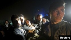 Afghan men carry a wounded man at the site of an explosion in Kabul on January 4.