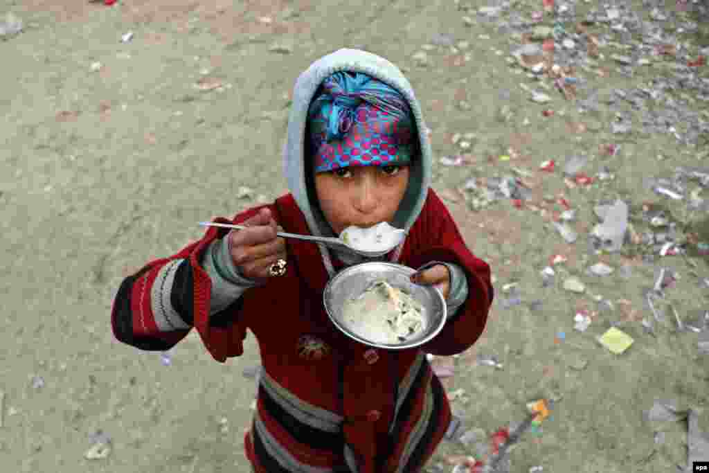 Ауғанстан астанасы Кабулдағы босқындар лагерінде тамақ ішіп тұрған бала.