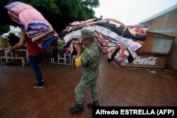 سرباز ارتش مکزیک در حال انتقال پتو به مناطقی که برای اسکان‌دادن شهروندان در نظر گرفته شده‌است