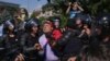 Police officers hold a man as thousands of Romanians hold rallies in major cities across the country and outside government headquarters in the capital, Bucharest, on August 10. (Reuters)