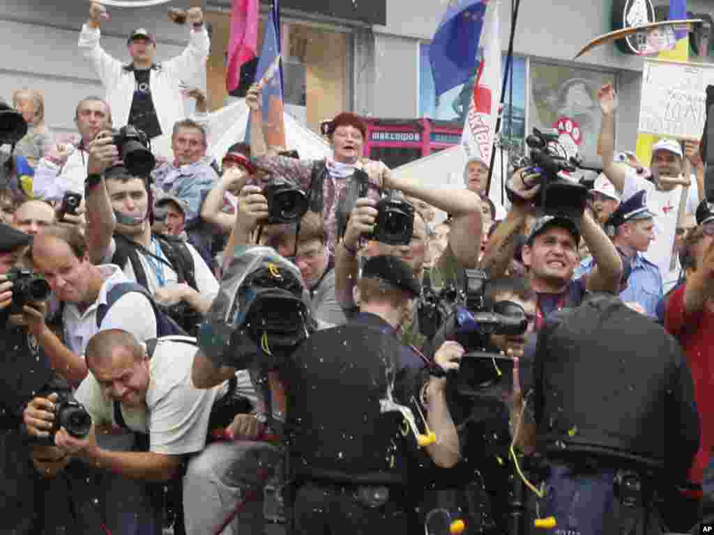 Susținători ai fostului premier ucrainean Iulia Timoşenko strigă şi aruncă ouă la fostul preşedinte ucrainean Viktor Iuşcenko, după ce acesta a depus mărturie la tribunal împotriva fostei sale aliate în timpul Revoluției Portocalii din 2004. Foto: Efrem Luikațky pentru AP