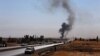 Smoke rises as Kurdish security forces withdraw from a checkpoint in Alton Kupri, outside of Irbil, on October 20.