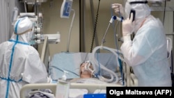 Medical workers tend to a COVID-19 patient at the intensive-care unit of a hospital in St. Petersburg.