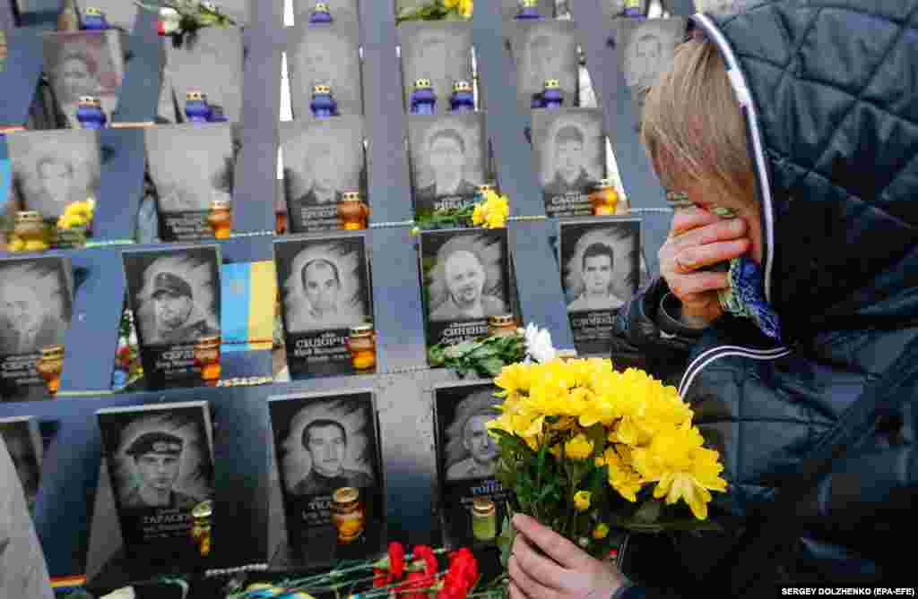 A Ukrainian woman reacts as she lays flowers at a memorial for Maidan activists who were killed during antigovernment protests in 2014, not far from the Independence Square in Kyiv. (epa-EFE/Sergey Dolzhenko)