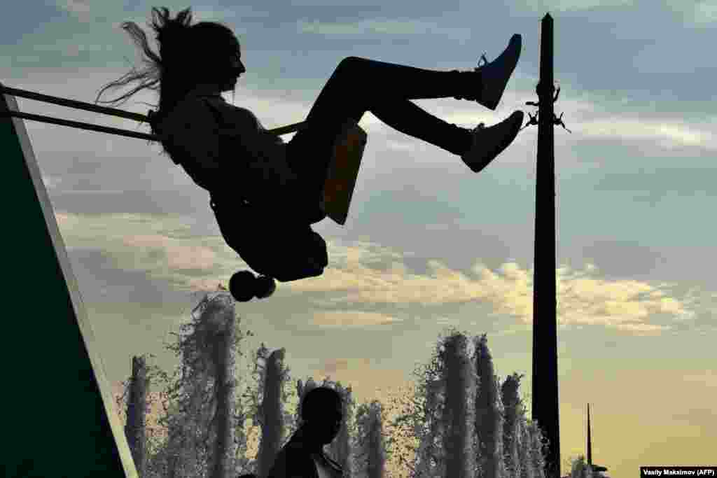 A woman sits on a swing on Poklonnaya Hill in western Moscow, Russia. (AFP/Vasily Maximov)