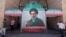 Commuters walk past a tiled image of current leader Ayatollah Mojtaba Khamenei near a Tehran subway station on May 9. 